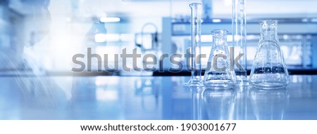 shadow of scientist and glass flask and cylinder equipment in medical science lab blue banner background Royalty-Free Stock Photo #1903001677