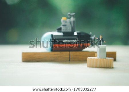 Miniature people of a politician stand on podium during a public speaking of submarine. Concept of policy