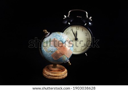 globe with plaster and clock on black background