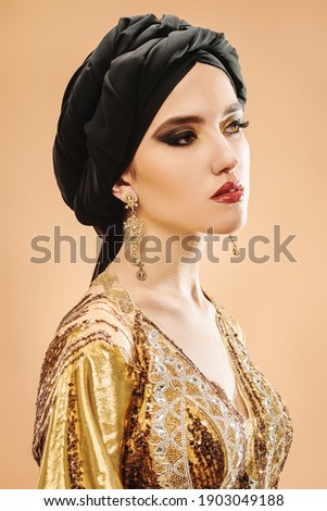 Portrait of a beautiful arabian woman in traditional dress, with traditional oriental make-up and black hijab. Oriental beauty woman. Make-up and cosmetics. 