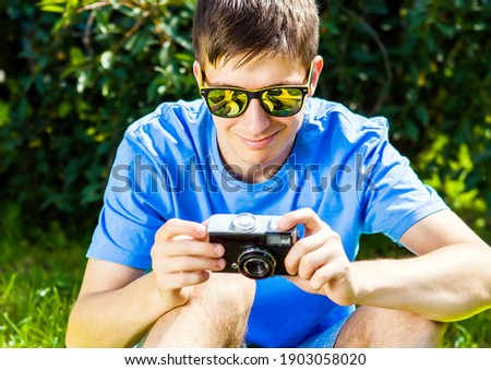 Young Man with a Vintage Photo Camera outdoor