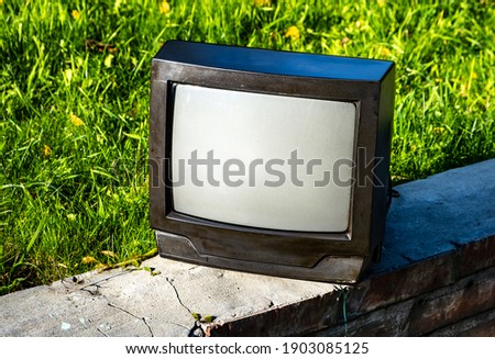 Old Analog Television Set on the Grass Background outdoor