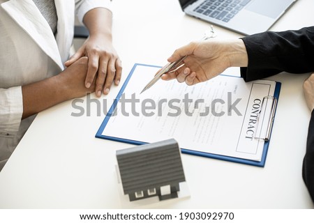 The home salesman and buyer is signing a purchase agreement after discussing the details, a contract to protect both parties' interests if the trade is not as agreed, Real estate trading ideas.