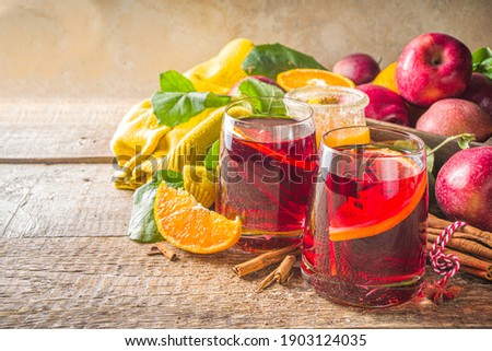 Traditional autumn winter alcohol drink. Hot autumn fruity sangria with citrus, apples and spices, wooden rustic background