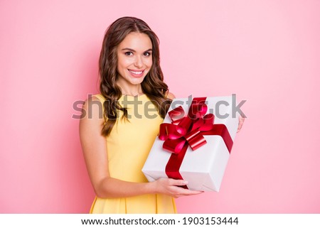 Photo of charming wavy hairdo cheerful lady hands hold giftbox toothy smile isolated on pink color background