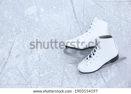 Pair of figure skates on ice, top view with space for text. Winter outdoors activities