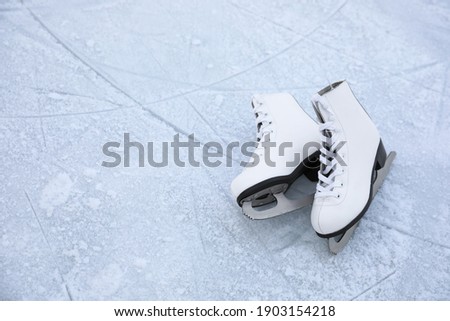 Figure skates with laces on ice, space for text. Winter outdoor activities