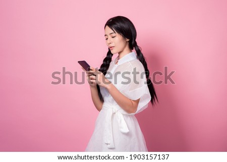 Happy smiling young asia woman with headphones enjoying listens to music over pink background