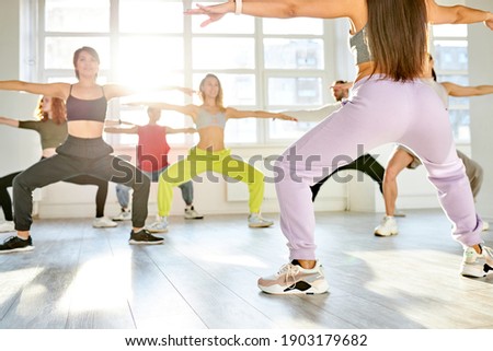 female choreographer showing dance moves to group of people, in dance studio. youth, lifestyle, dance concept