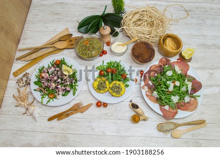 Composition of several Italian dishes, special Italian ingredients and preparations. Picture in top view with culinary decoration in background.