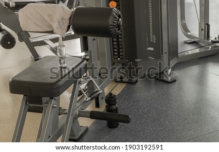 Alcohol sanitizer spray and fabric on exercise machine at gym. Equipment for doing sport exercises, Selective focus.