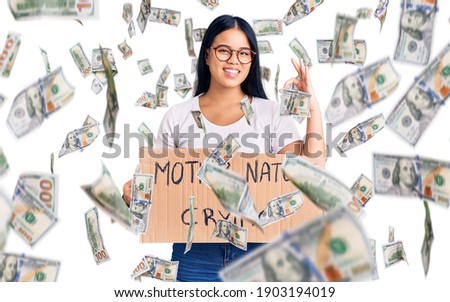 Young beautiful asian girl holding mother nature is crying protest cardboard banner doing ok sign with fingers, smiling friendly gesturing excellent symbol