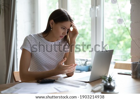 Went into debt. Annoyed young lady look on pc screen calculate too big sum of tax utility bills mortgage loan payment. Confused female self employed enterpreneur miss term to pay tax receive penalty Royalty-Free Stock Photo #1903214938