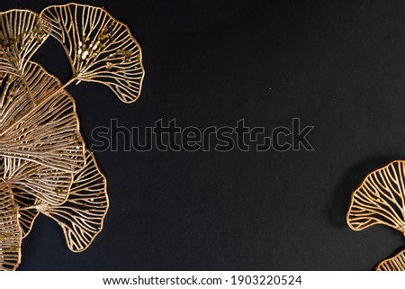 Golden tropical flowers frame on black background, art deco style, top view