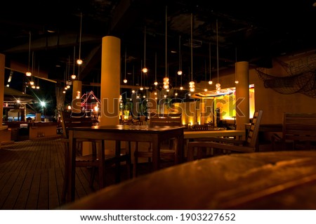In a bar at night. Interior with no one inside. Warm lights and cozy ambience. Royalty-Free Stock Photo #1903227652