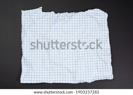 texture of crumpled white paper in a cage, blue lines, torn edges on a black background
