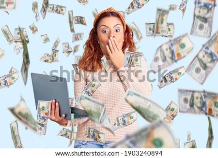 Young latin woman holding laptop covering mouth with hand, shocked and afraid for mistake. surprised expression