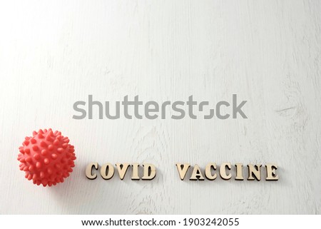 Covid vaccine, lettering in english from letters next to red ball, copy space