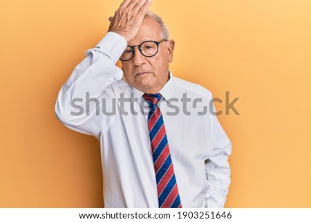 Senior caucasian man wearing business clothes surprised with hand on head for mistake, remember error. forgot, bad memory concept.  Royalty-Free Stock Photo #1903251646