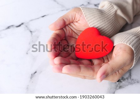 women holding red heart close up 