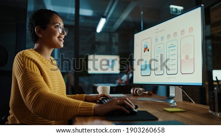 Young Latina Designer Working on a Desktop Computer in Creative Office. Beautiful Diverse Multiethnic Female is Developing a New App Design and User Interface in a Digital Graphics Editing Software.