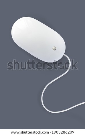 Simple white computer mouse with cord isolated on dark grey background, minimal style