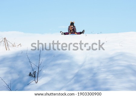 A cute ten years old teenage girl having fun on snow tube on a winter day. Wintertime, entertainment, activity, childhood, holidays concept.