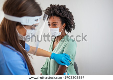 Doctor vaccinating patient in private clinic with copy space. Doctor giving injection to woman at hospital.  Nurse holding syringe and using cotton before make Covid-19 or coronavirus vaccine.