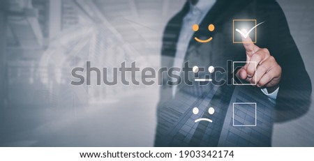 Businessmen are choosing screen on the happy Smiley face icon to give satisfaction in service, Customer service and Satisfaction concept, rating very impressed. Royalty-Free Stock Photo #1903342174