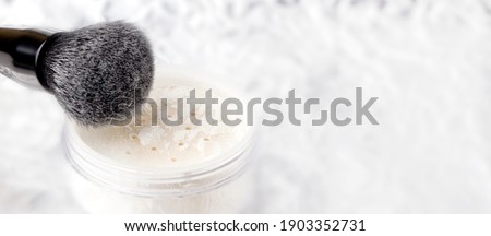 White matting powder with a black brush on a white background. Royalty-Free Stock Photo #1903352731