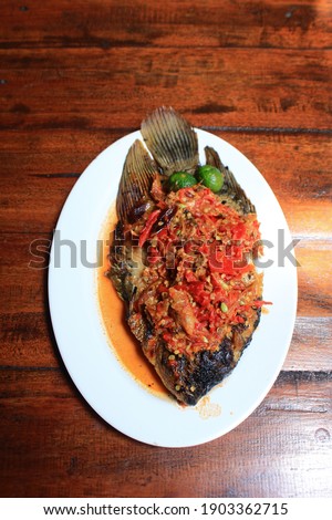 Gurame bakar sambal cobek is popular indonesian food. Delicious Grilled Gurame Fish with raw red chili sauce.