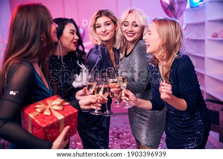 Five pleased attractive dressy female coworkers raising glasses to their success at the office party Royalty-Free Stock Photo #1903396939