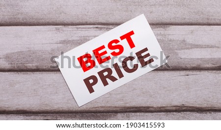 On a wooden background, there is a white card with red text BEST PRICE