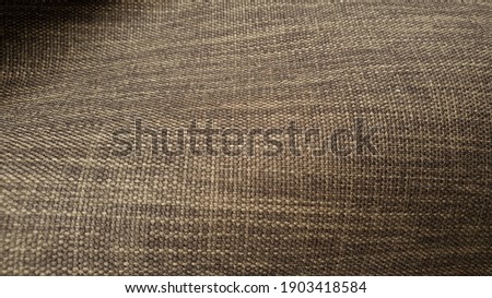 close up brown natural wavy sackcloth texture background. rough burlap canvas wallpaper with space for text.