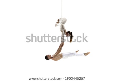 Weightless. Couple of acrobats, circus athletes isolated on white studio background. Training perfect balanced in flight, rhythmic gymnastics artists practicing with equipment. Grace in performance.