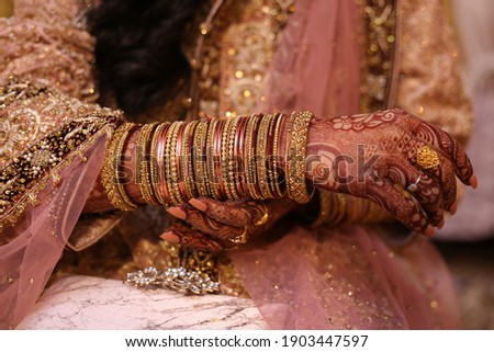 Indian Pakistani Desi Bride hands, holding her bangles  Royalty-Free Stock Photo #1903447597