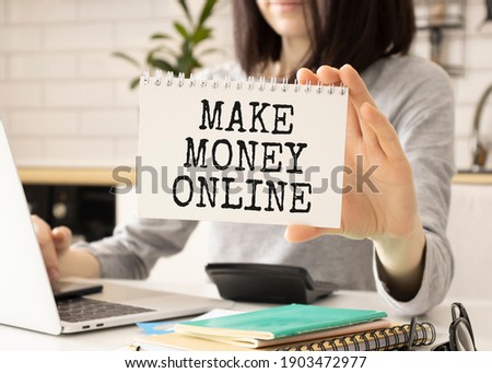 Business man pointing to transparent board with text: Make Money Online