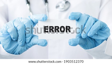 Doctor holding card in hands and pointing the word ERROR