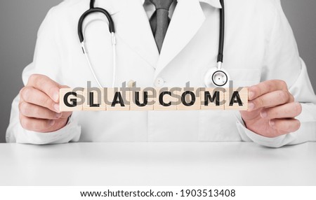 Doctor holds wooden cubes in his hands with text GLAUCOMA Royalty-Free Stock Photo #1903513408