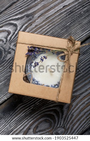 Decorative candle in craft packaging. Tied with a cord and decorated with lavender branches.