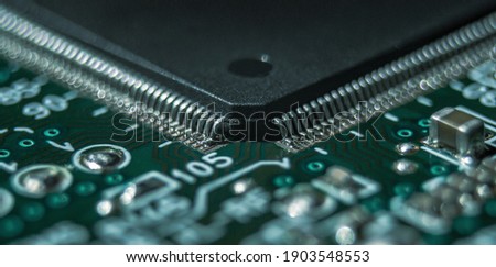 macro photography of integrated circuit in QFP package assembled on printed circuit board