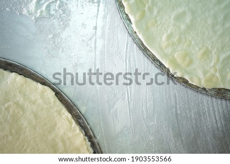 Blanks for the production of pizza dough on a metal background top view with copy space.