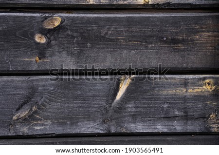 Old wood planks with knots and scratches, dark wood texture for background.
