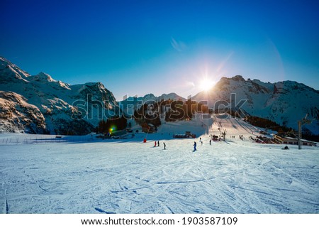 Last rays of sunset light over snow ski resort in French Alps in Savoie region