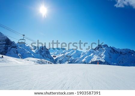 Alps mountain peaks and clean empty ski trails in Pralognan-la-Vanoise range over snowy tops Royalty-Free Stock Photo #1903587391