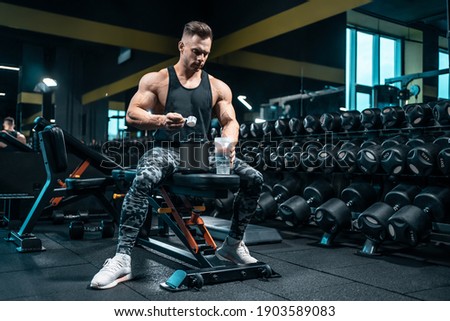 athlete man preparing protein cocktail or use sport nutrition supplement in gym Royalty-Free Stock Photo #1903589083
