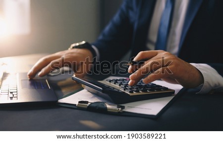 Businessman calculating the financial statement of his business. Accounting and Tax. Royalty-Free Stock Photo #1903589221