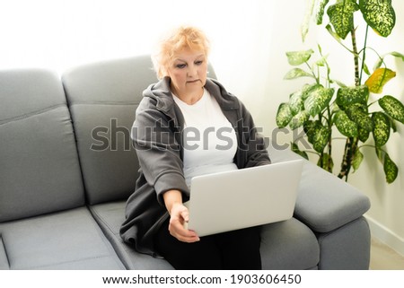 Elder woman using a laptop computer at home