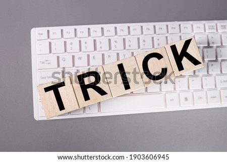 trick, text on wood cubes on white keyboard