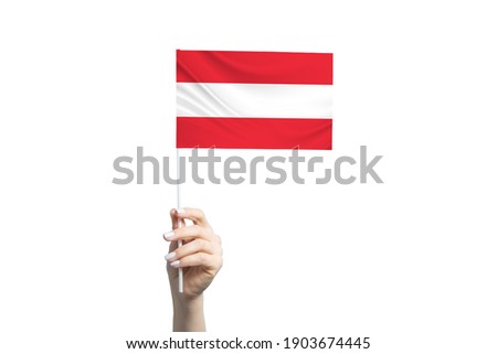Beautiful female hand holding Austria flag, isolated on white background.